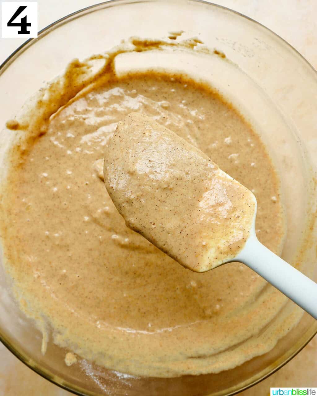 spatula mixing pancake batter in a bowl.