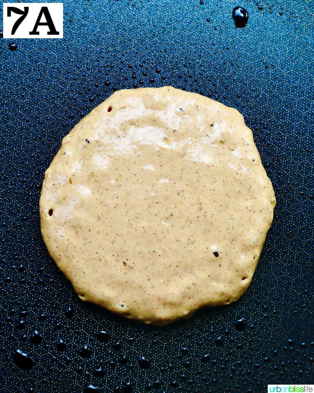 pancake circle cooking on a griddle pan.