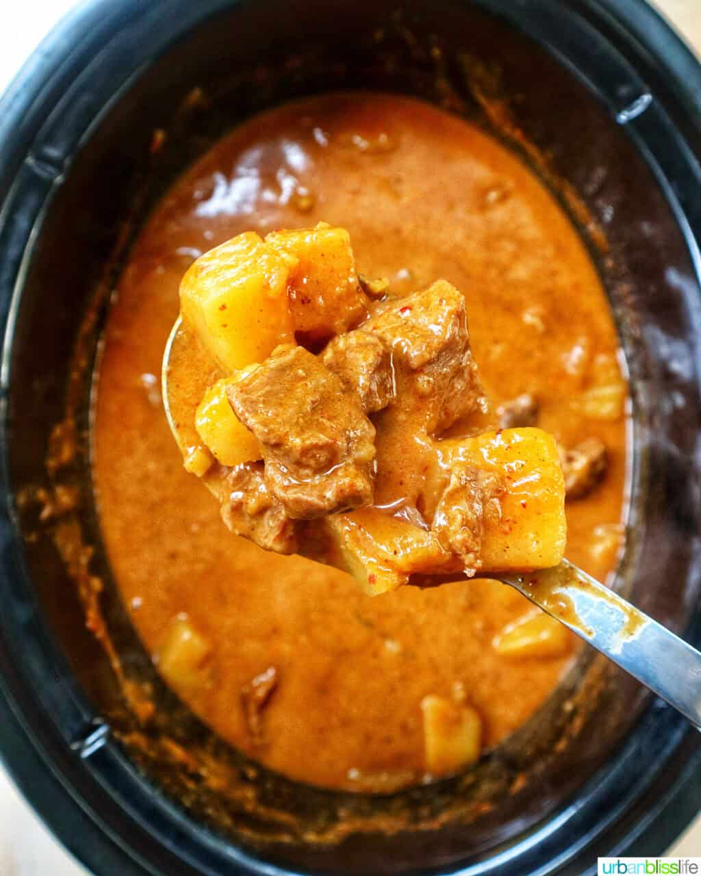 slow cooker beef massaman curry cooking in a crockpot slow cooker.