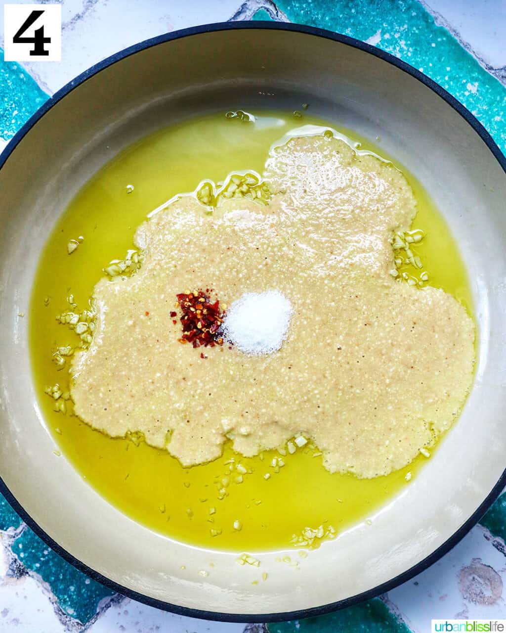 tahini and spices added to garlic and olive oil in a saucepan.