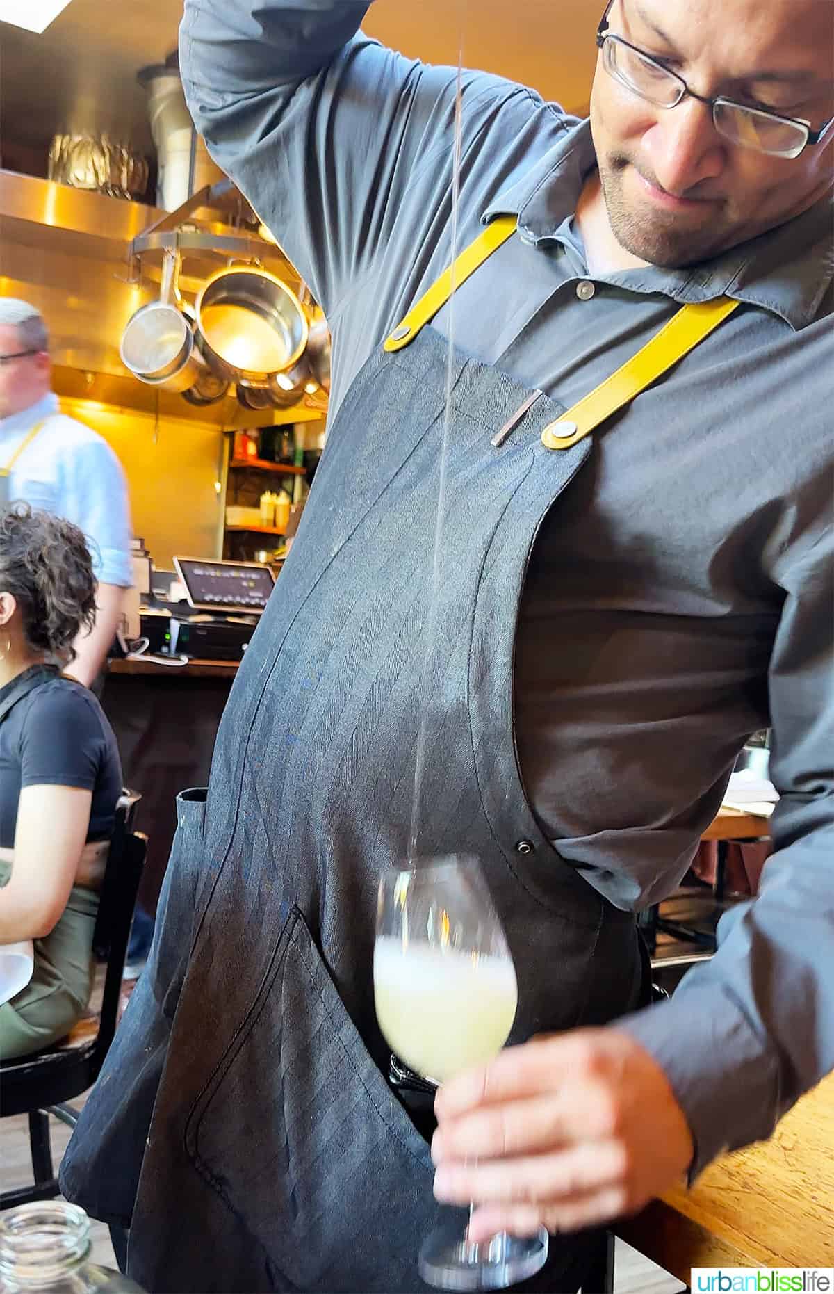 waiter at Urdaneta restaurant in Portland pouring Txakoli wine