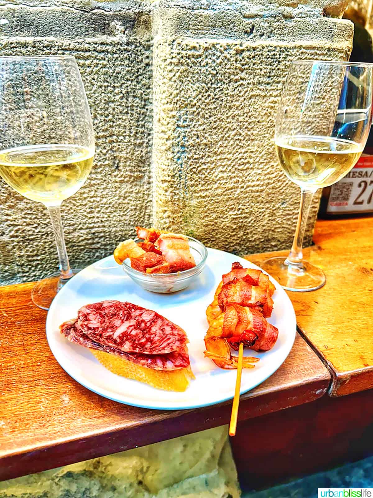 two glasses of txakoli wine with pintxos