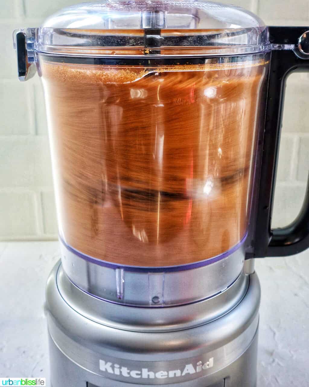 Biscoff cookie truffle dough whirling in a food processor.