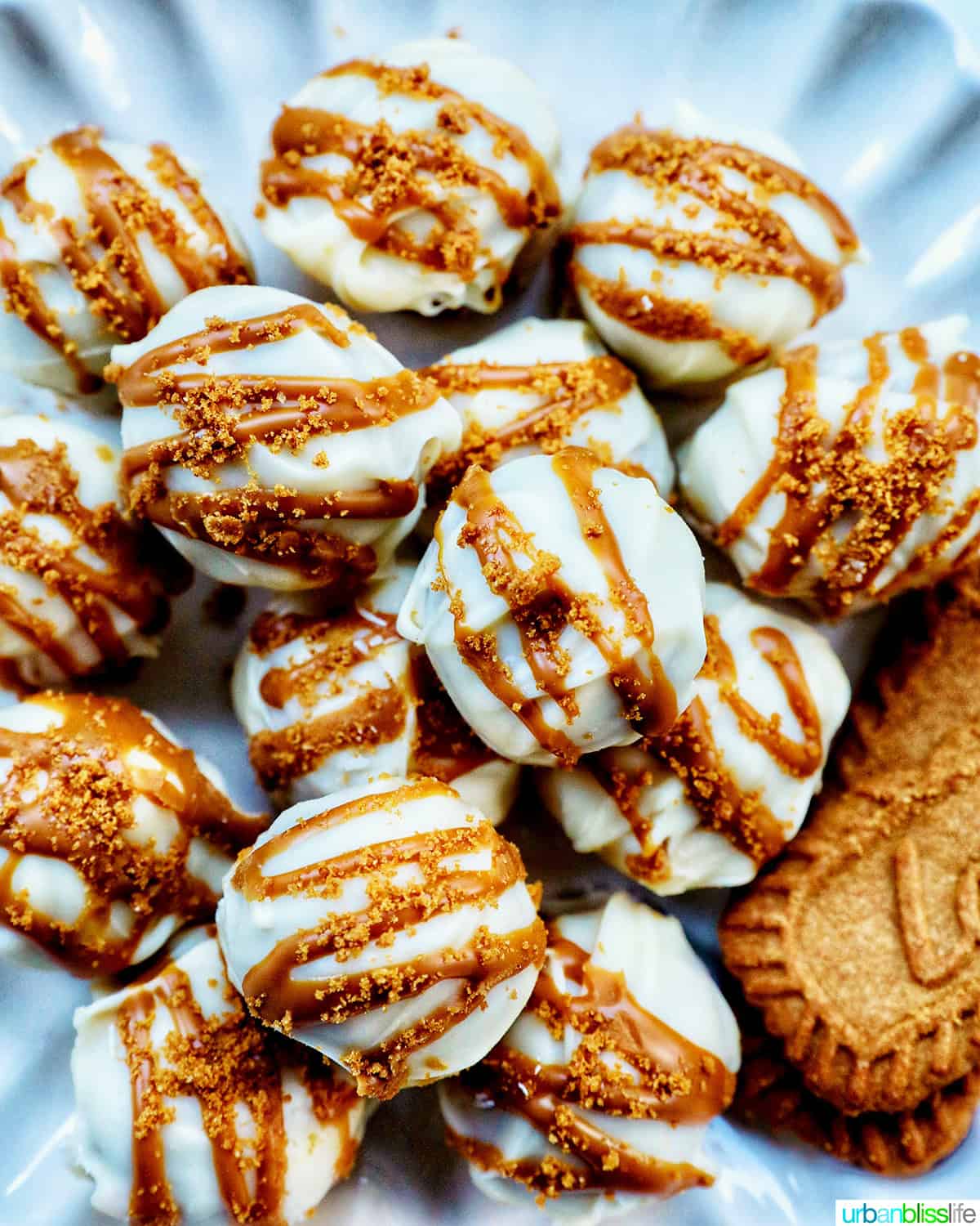 pile of Biscoff truffles on a plate with Biscoff cookies.