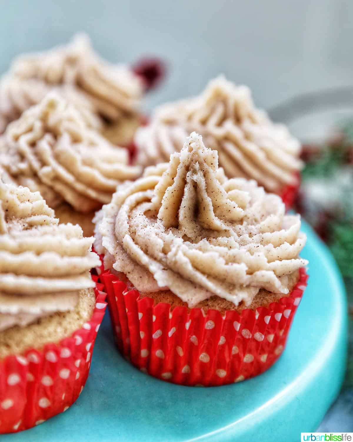 side view of several cinnamon cupcakes on a blue cake pedestal.