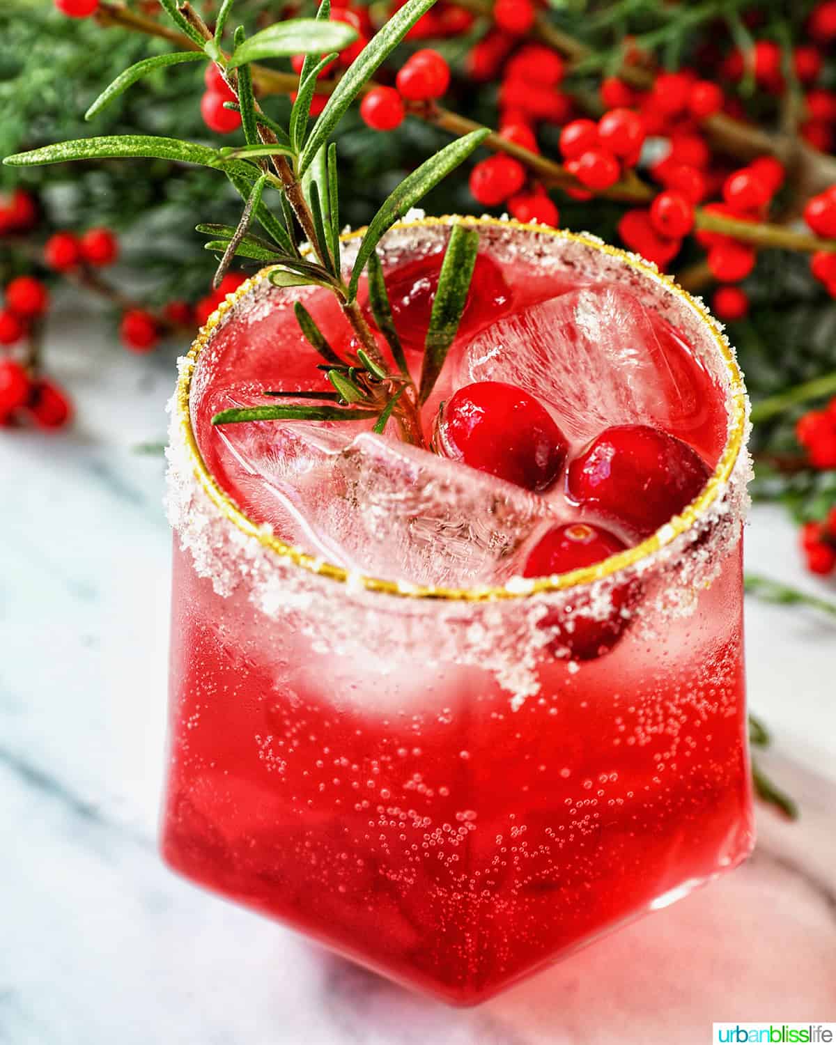 glass of cranberry mocktail drink with festive christmas decorations.