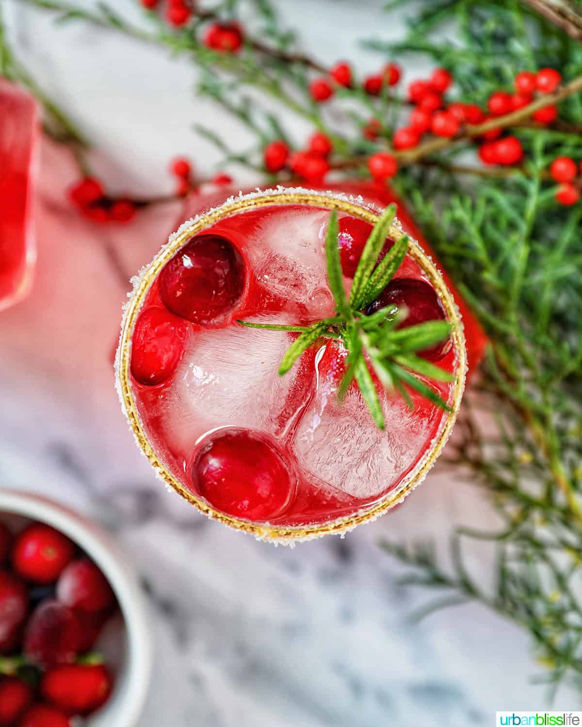 glass of cranberry mocktail drink with festive christmas decorations.