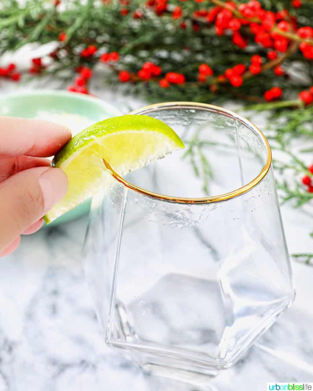 lime over the rim of a cocktail glass.