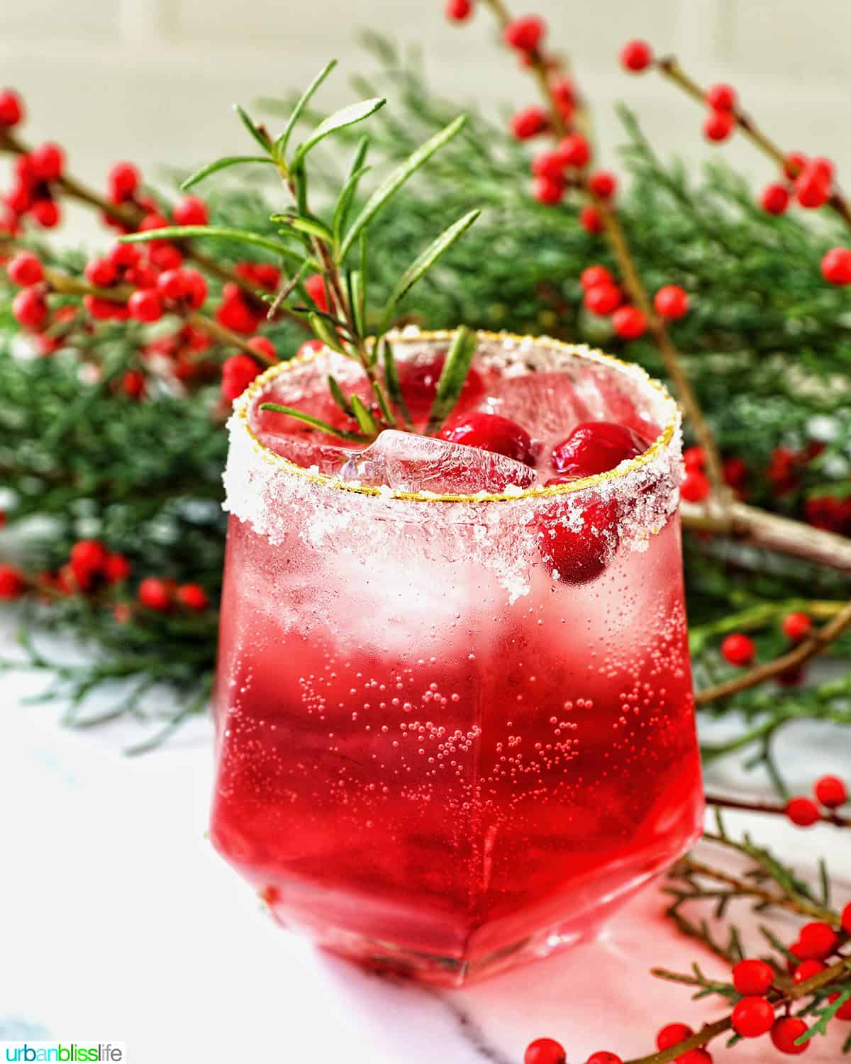 glass of cranberry mocktail drink with festive christmas decorations.