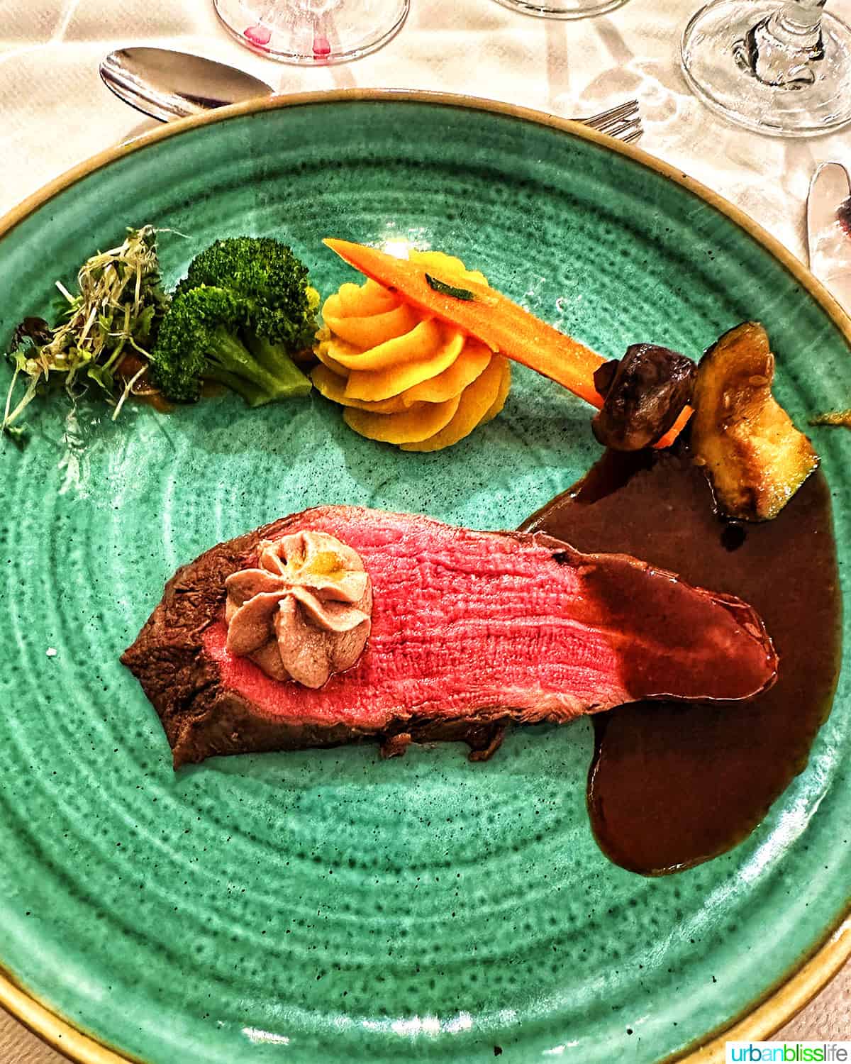 steak with sides on a green plate on AmaWaterways river cruise.