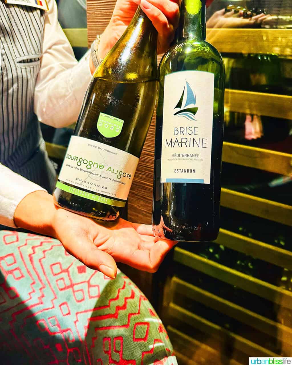 waiter holding two bottles of French wine on an AmaWaterways river cruise.
