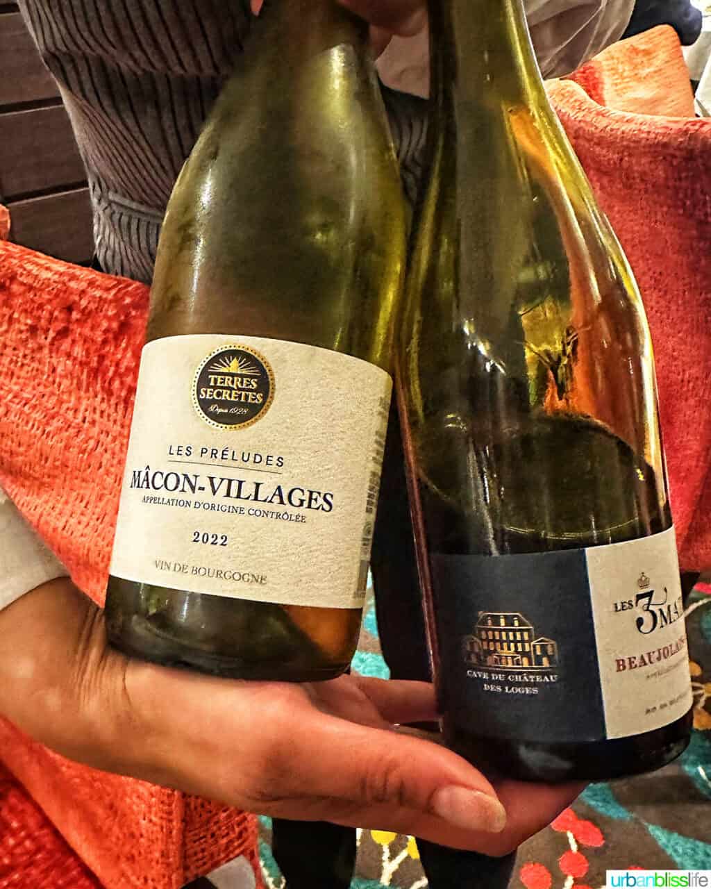 waiter holding two bottles of French wine on an AmaWaterways river cruise.
