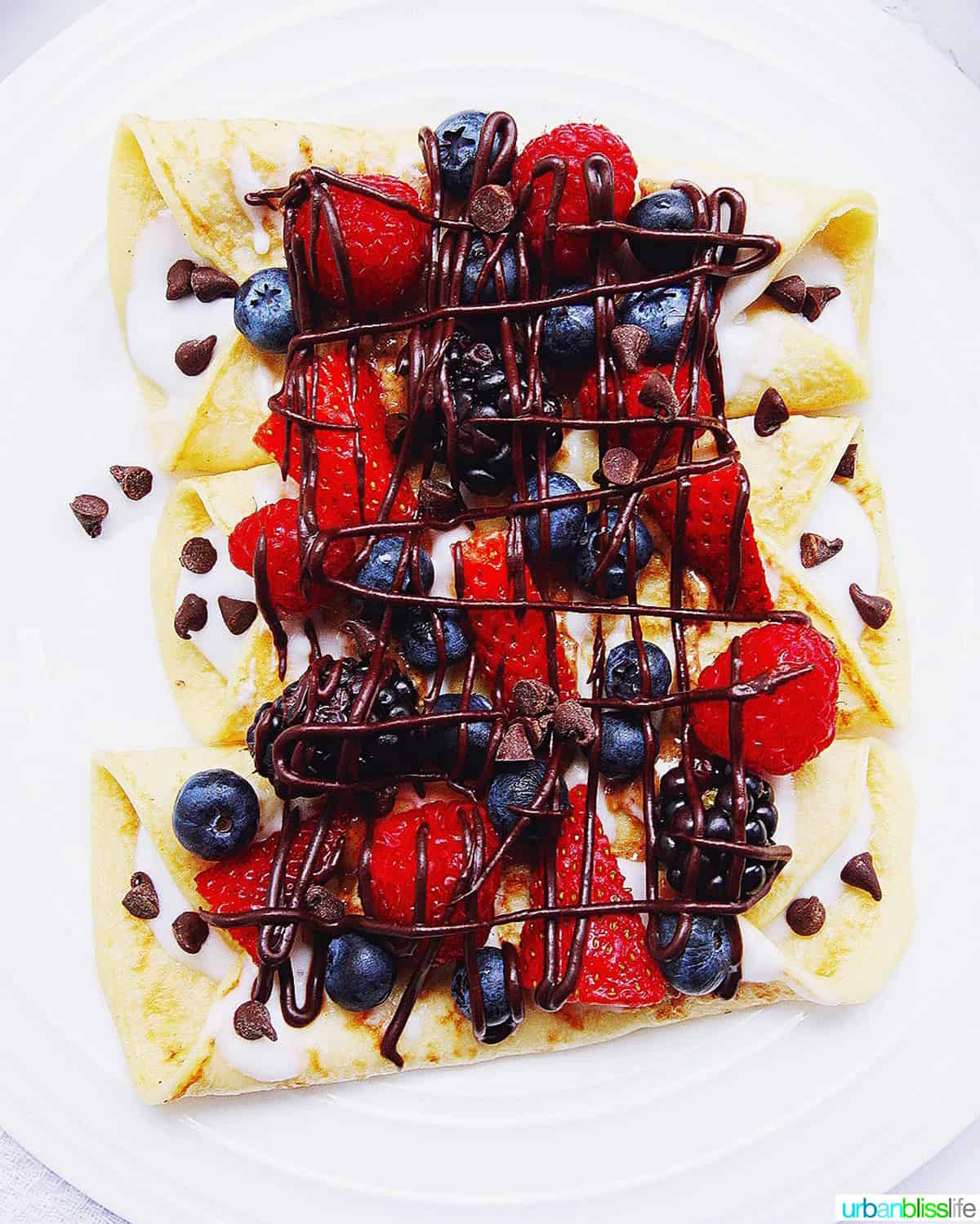 crepes with mixed berries and chocolate sauce drizzled over.