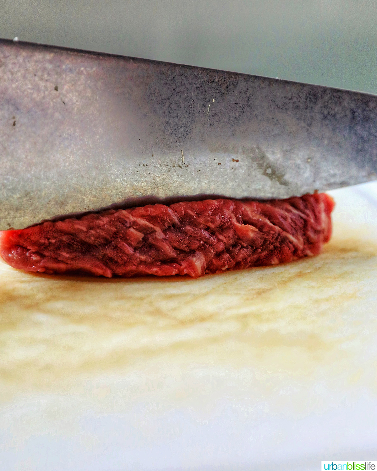 knife slicing beef on the bias.