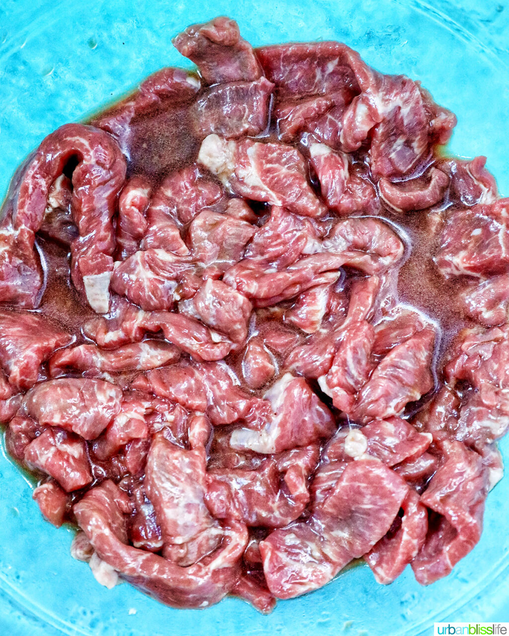 sliced beef in sauce in a bowl.