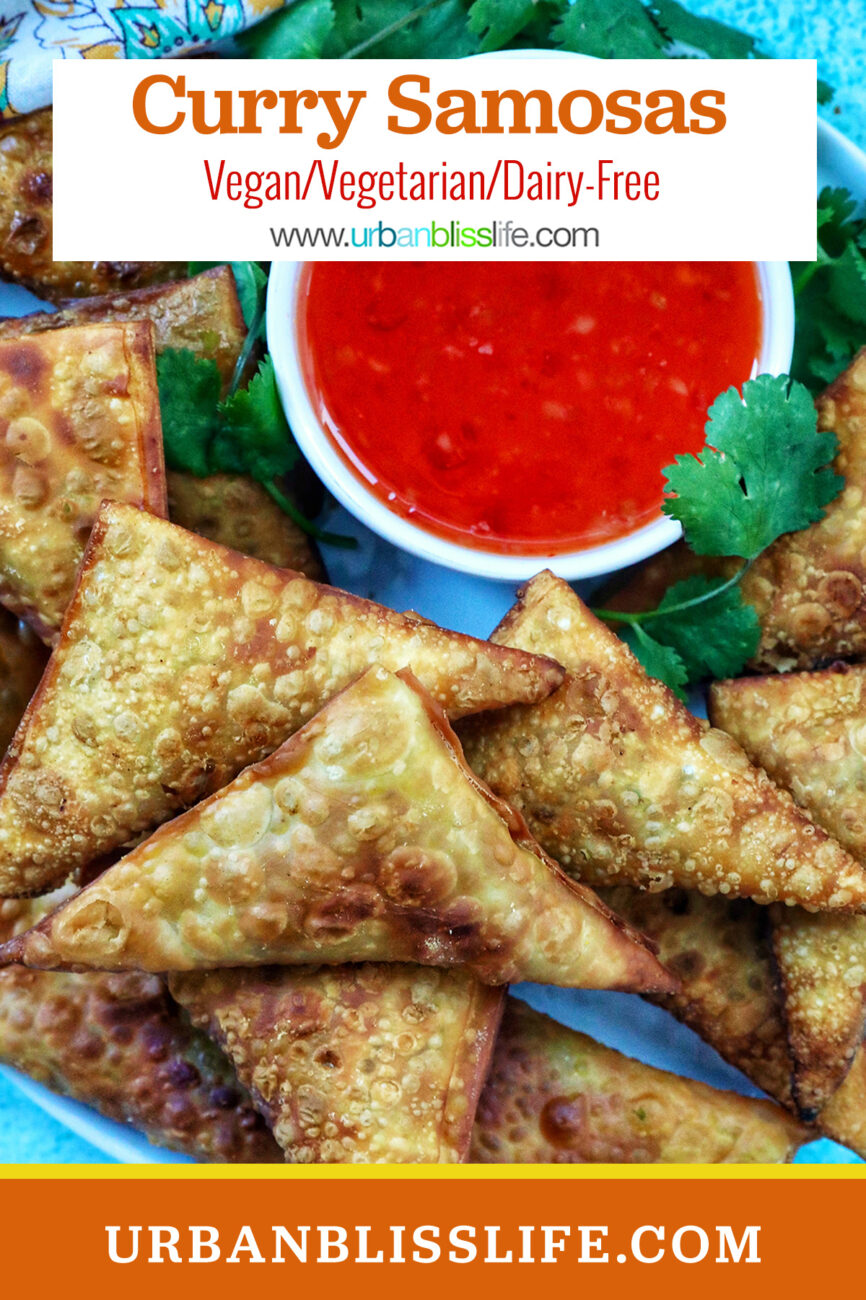 plate full of vegan curry samosas with a side of sweet chili dipping sauce and herb garnish and title text overlay.