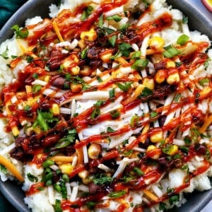 loaded potato bowl with mashed potatoes, beans, corn, cheese, and herbs.