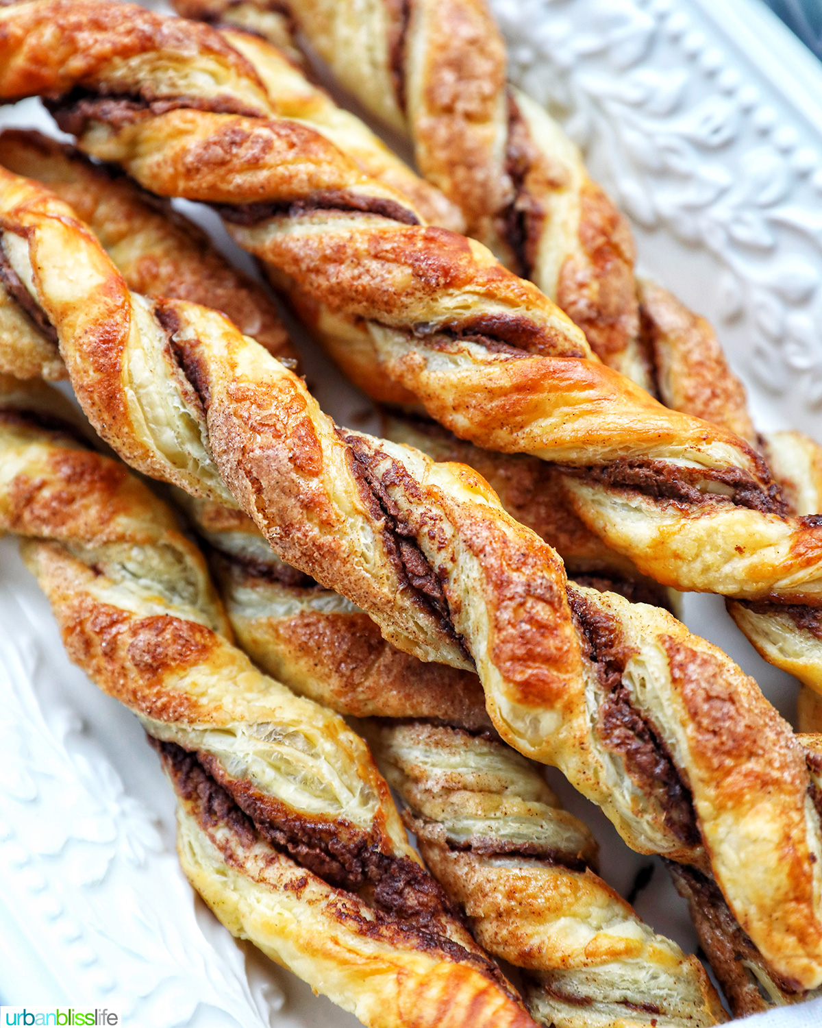 puff pastry chocolate twists on a white serving tray.
