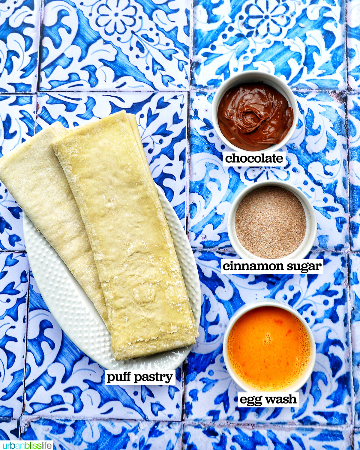ingredients to make puff pastry chocolate twists on a blue and white table.