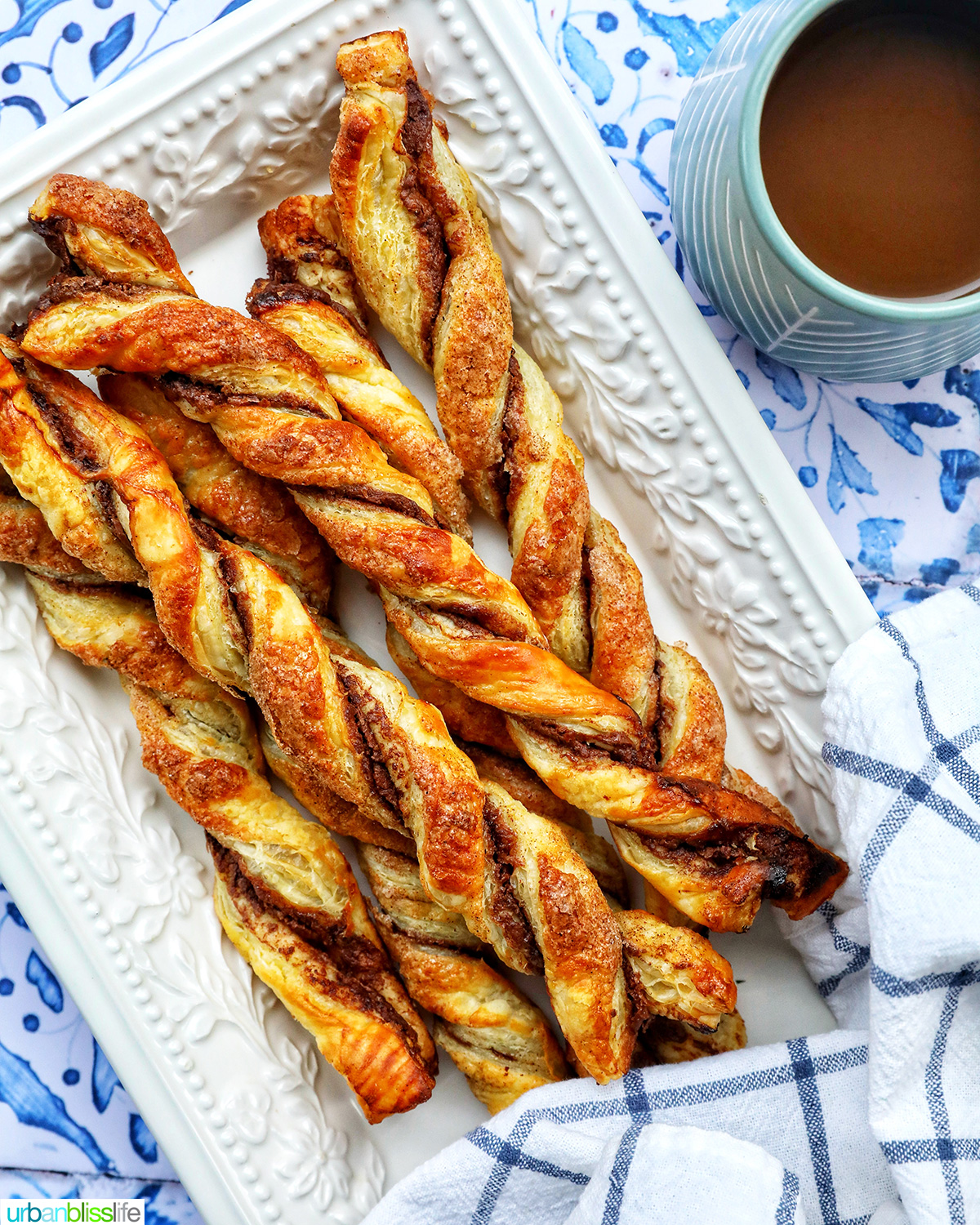 puff pastry chocolate twists on a white serving tray with side of melted dipping chocolate.