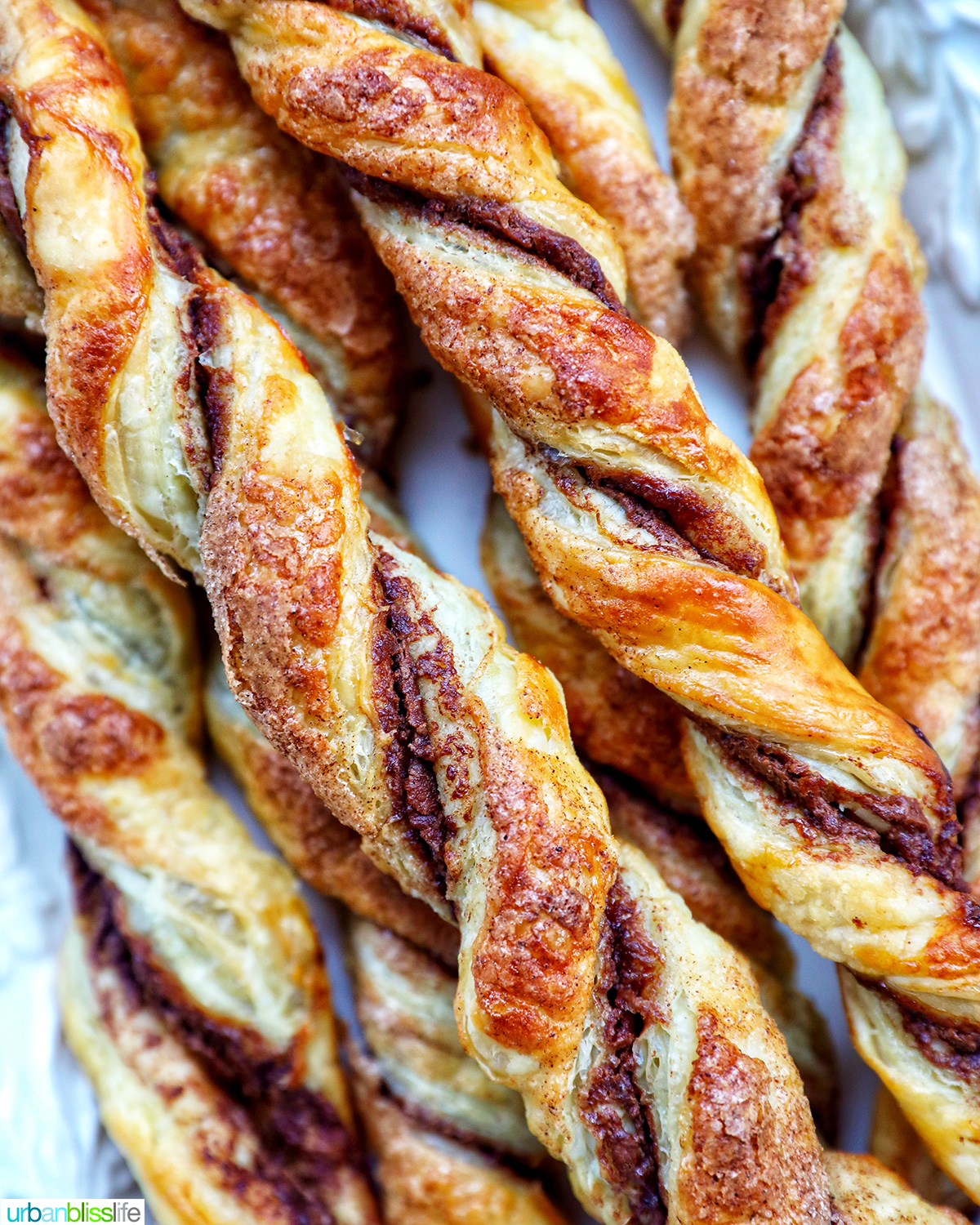 puff pastry chocolate twists on a white serving tray.