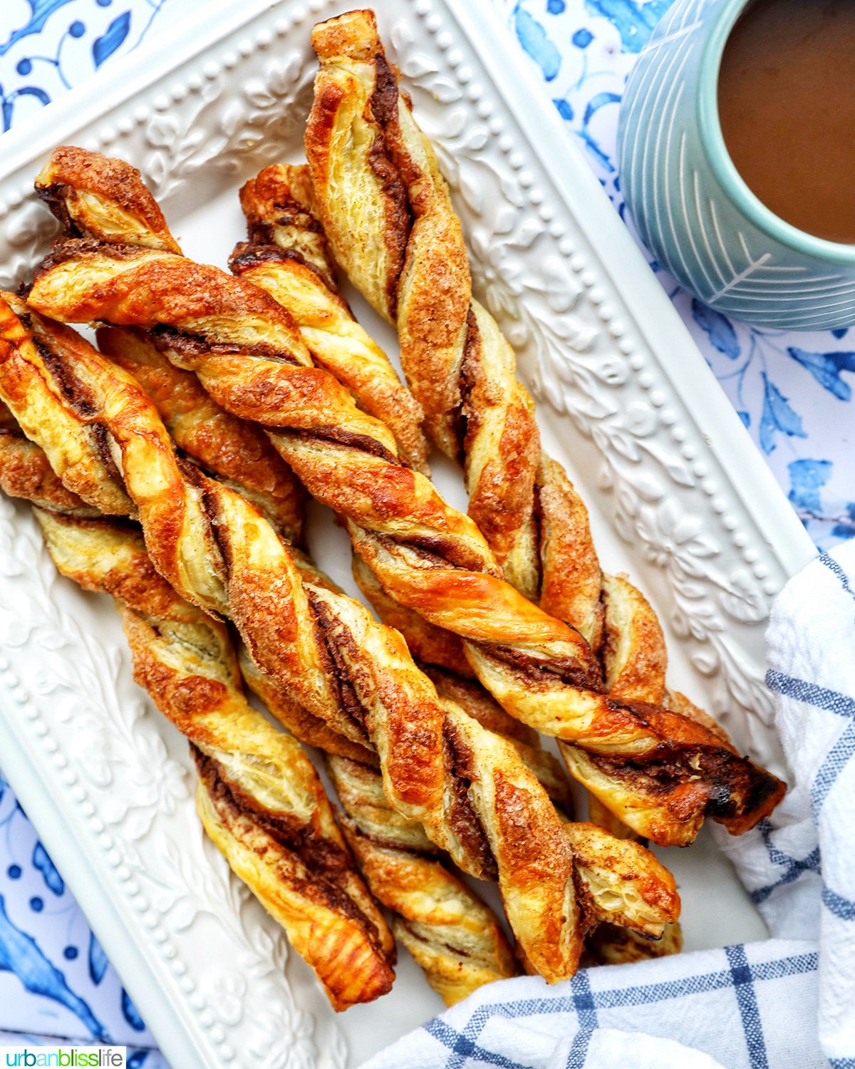 puff pastry chocolate twists on a white serving tray with side of melted dipping chocolate.