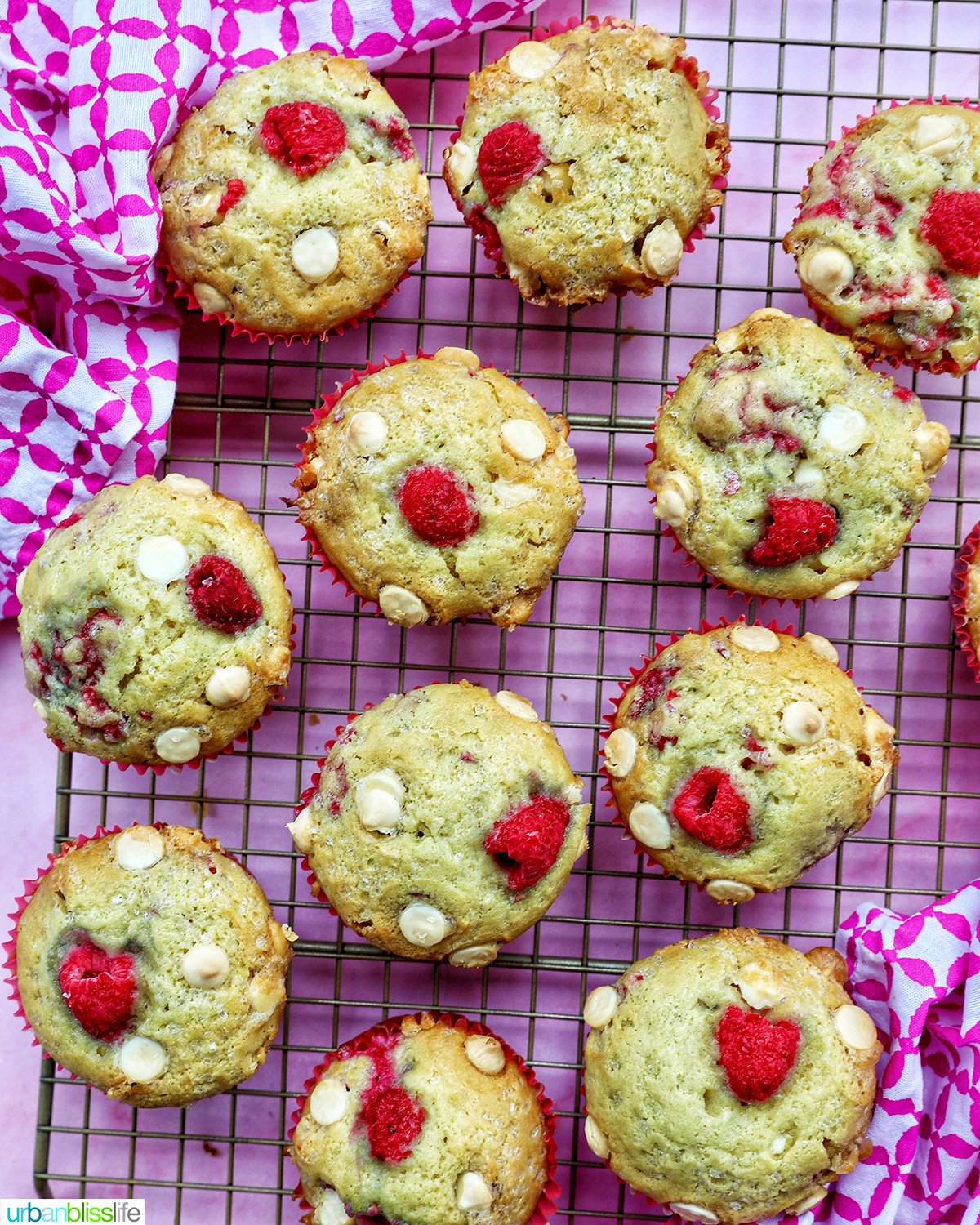 raspberry white chocolate chip muffins on a wire rack.