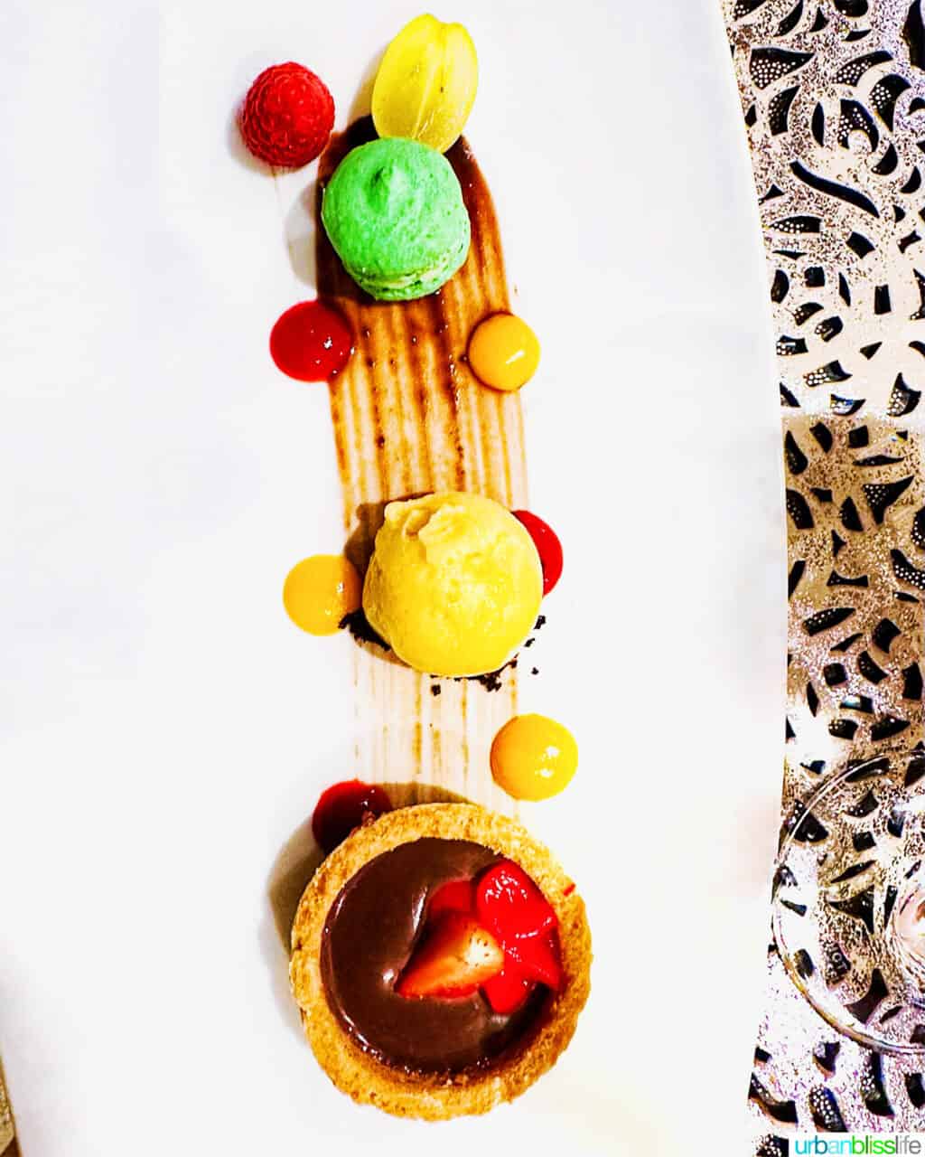 salted caramel chocolate tart, lime macaron, cherry sorbet, fresh berries at Chef's Table dinner on AmaWaterways river cruise.