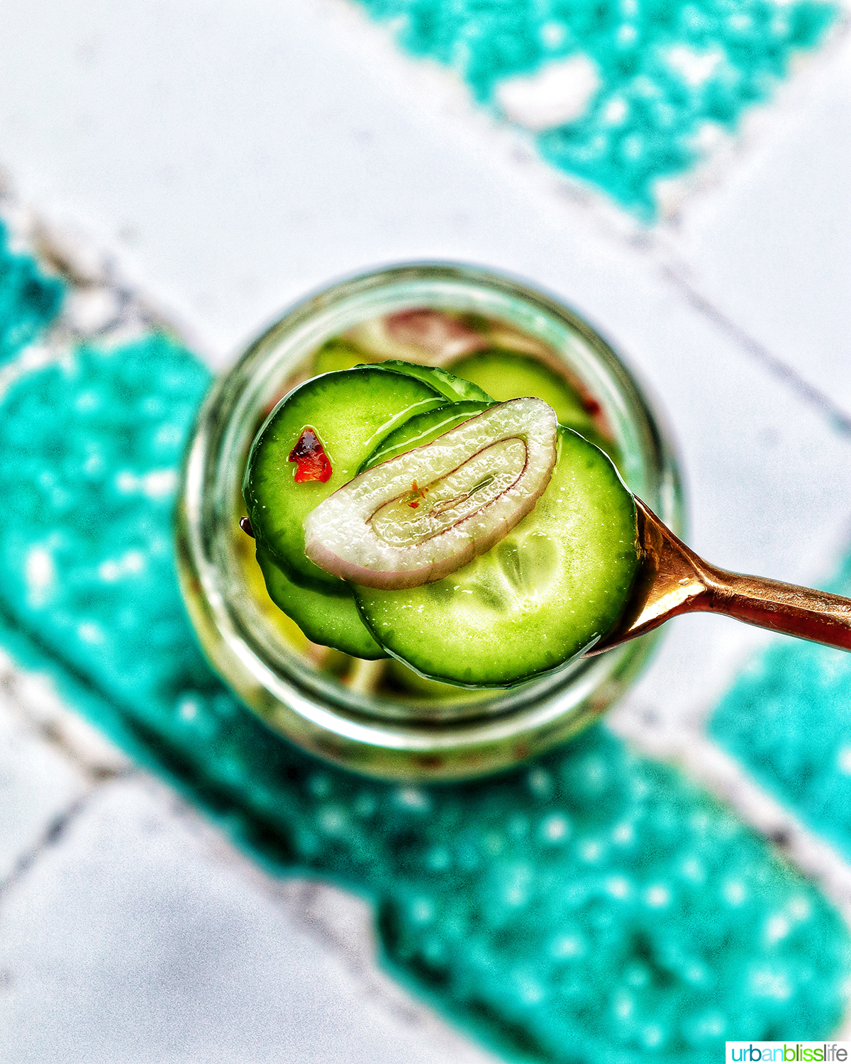forkful of pickled cucumbers over a jar of Asian pickled cucumbers.