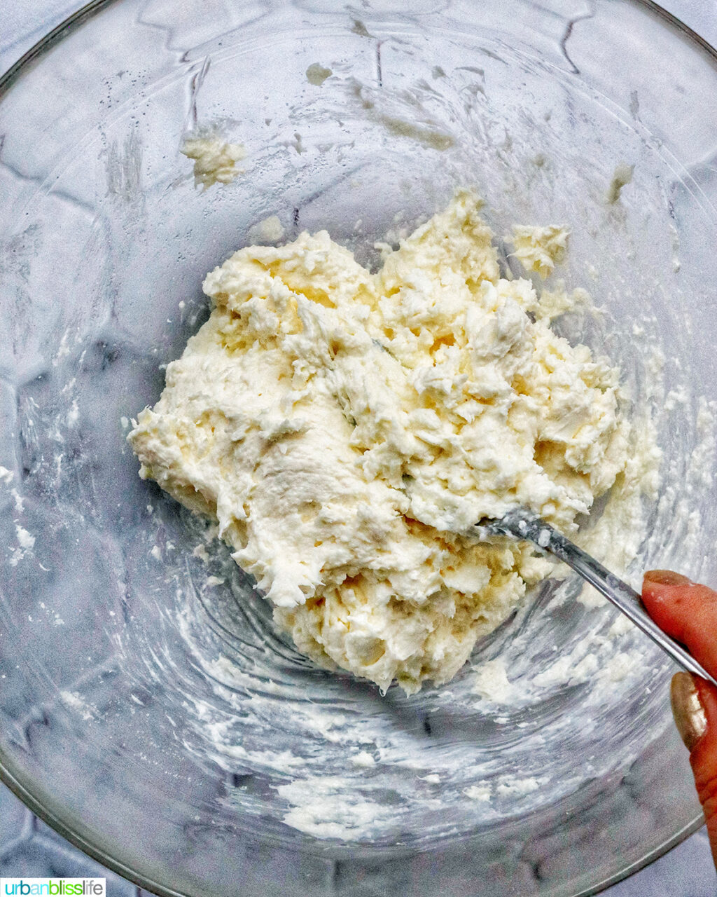 mixing a cream cheese mixture in a bowl.