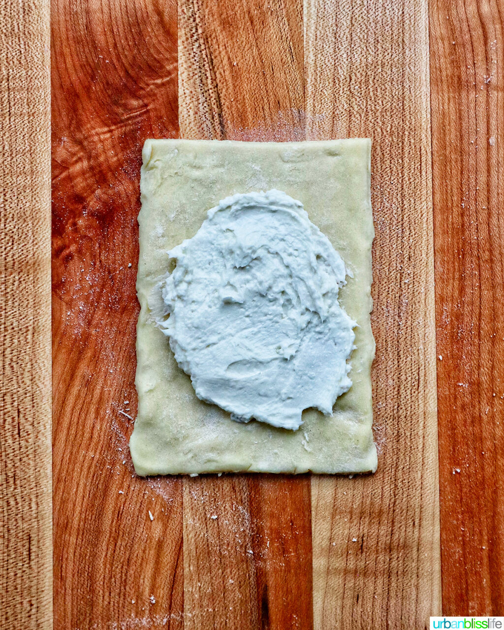 cream cheese and puff pastry on a cuting board.