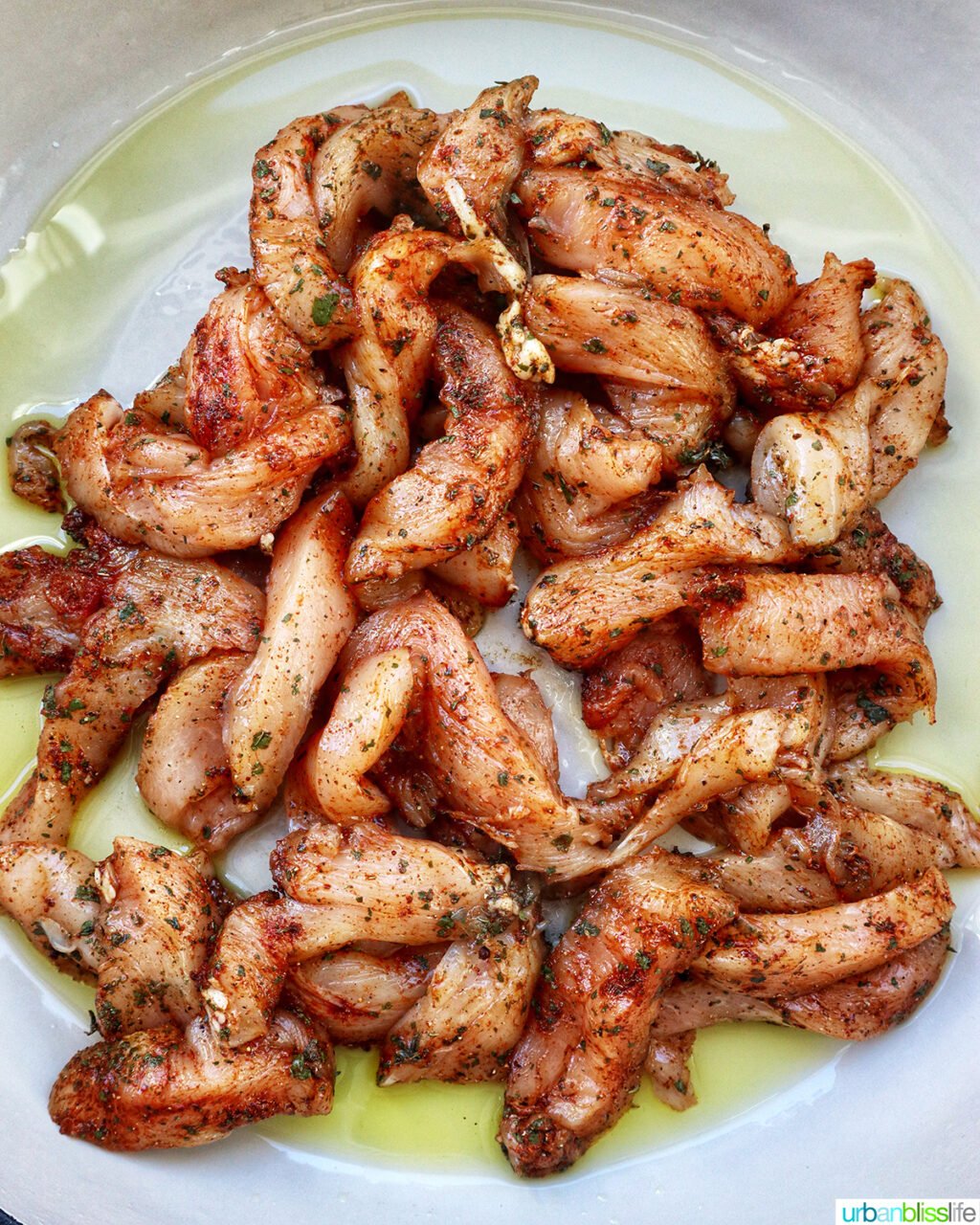 sliced chicken cooking in a pan.