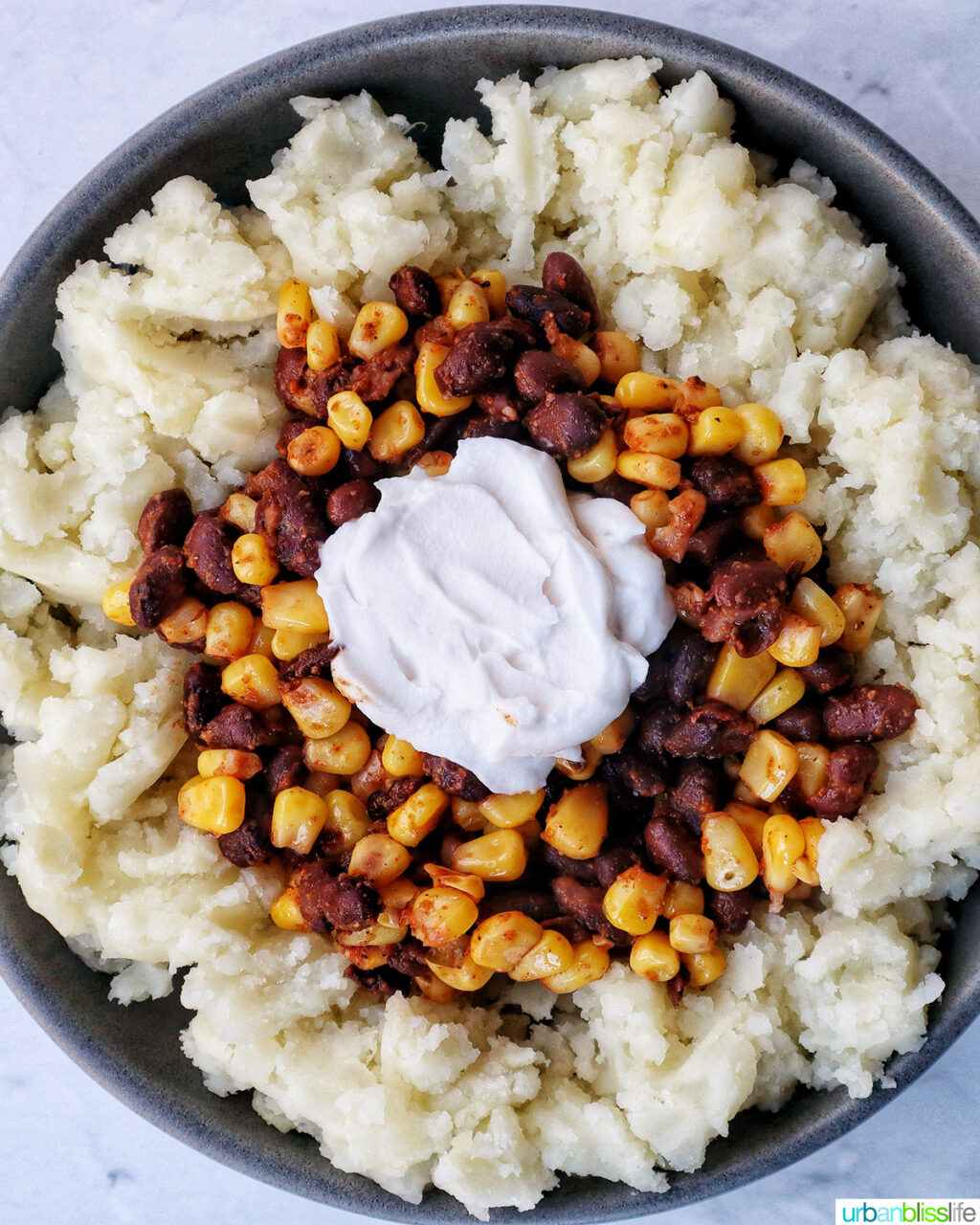 loaded potato bowl with mashed potatoes, beans, corn,sour cream.