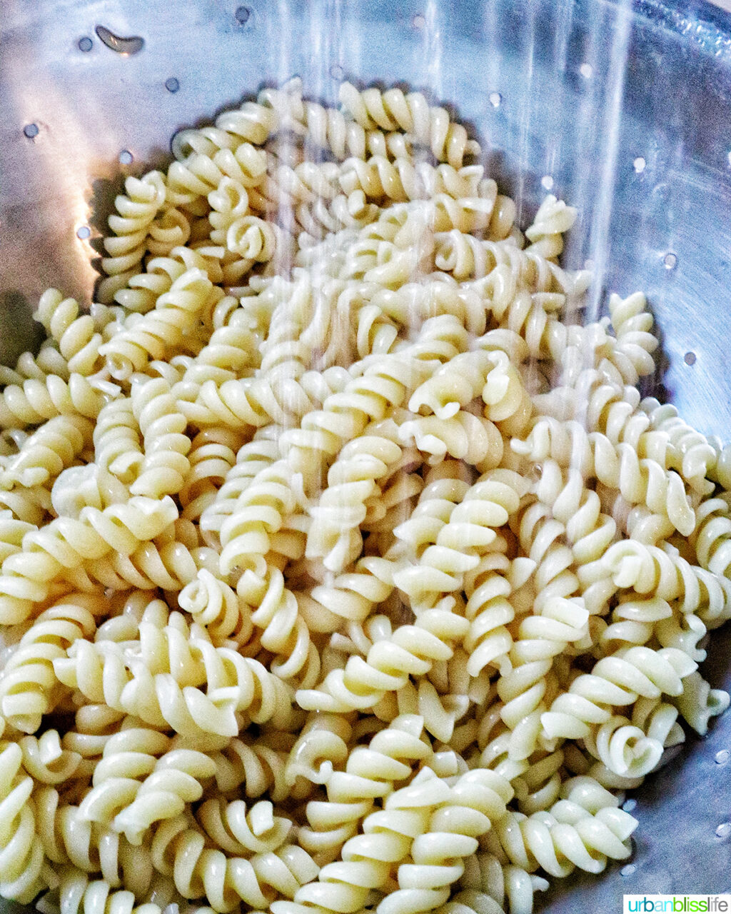 pasta being rinsed and drained.