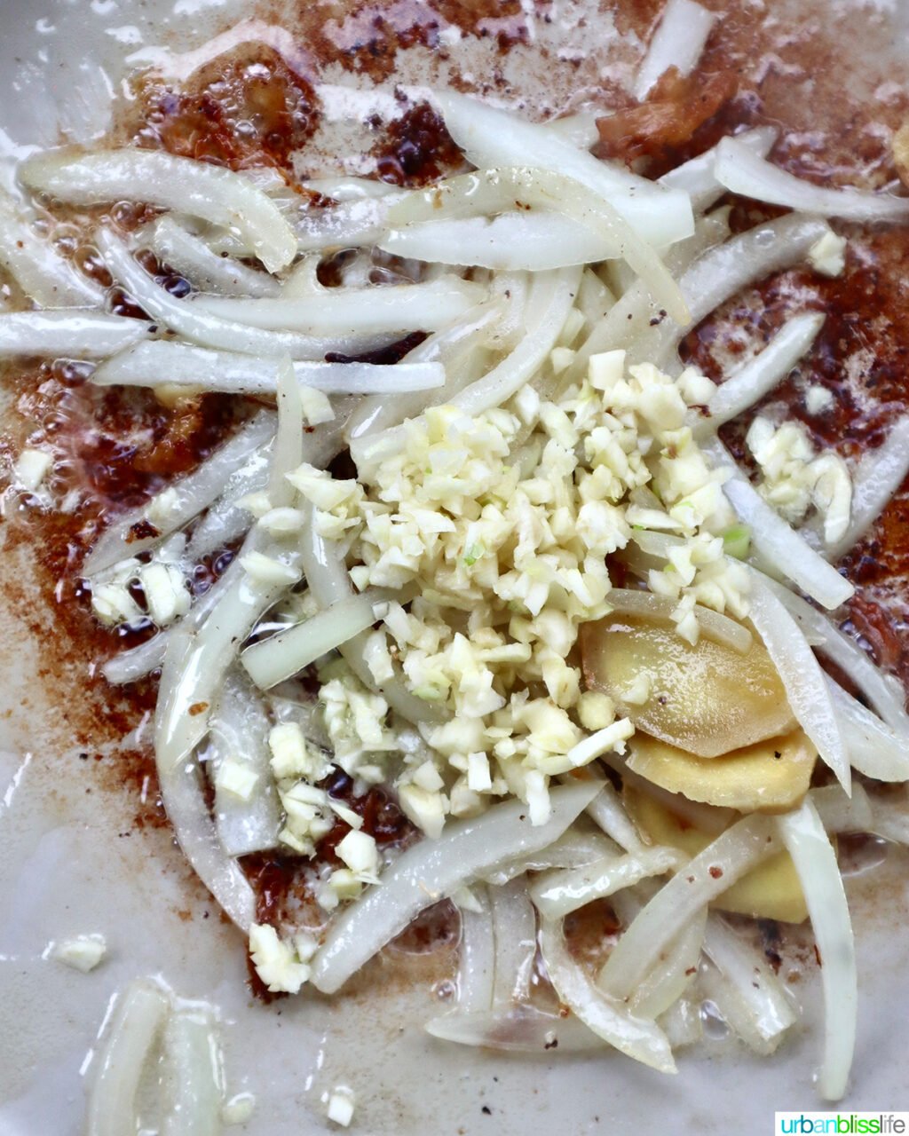 sliced onions, ginger, and minced garlic in a skillet.