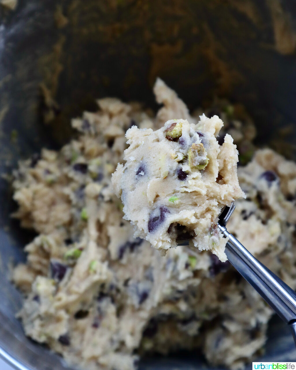 scoop of cookie batter above a bowl of cookie batter.