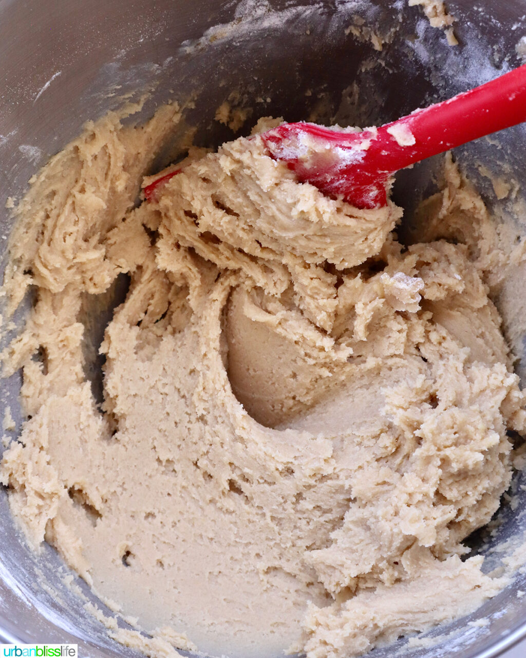 red spatula mixing cookie batter.