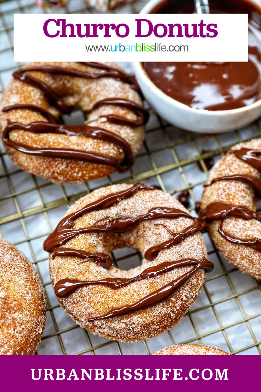 churro donuts on a cooling rack with chocolate drizzle.