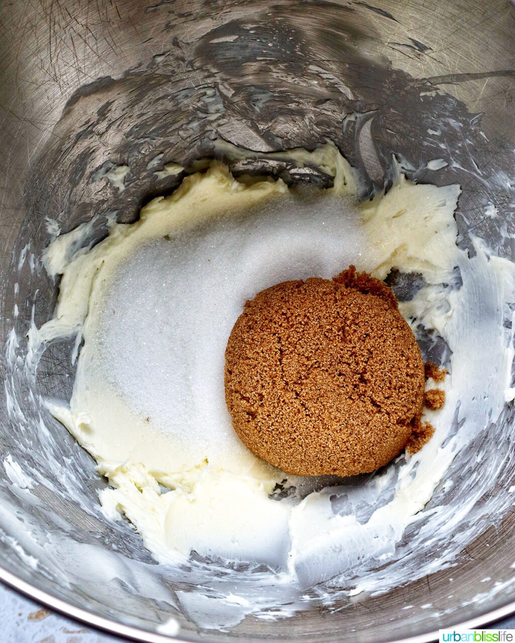 granulated sugar and light brown sugar over creamed butter in a bowl.