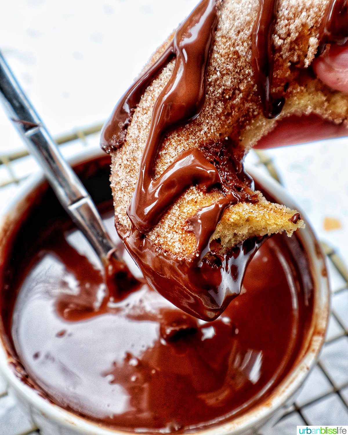 churro donuts on a cooling rack with chocolate drizzle.