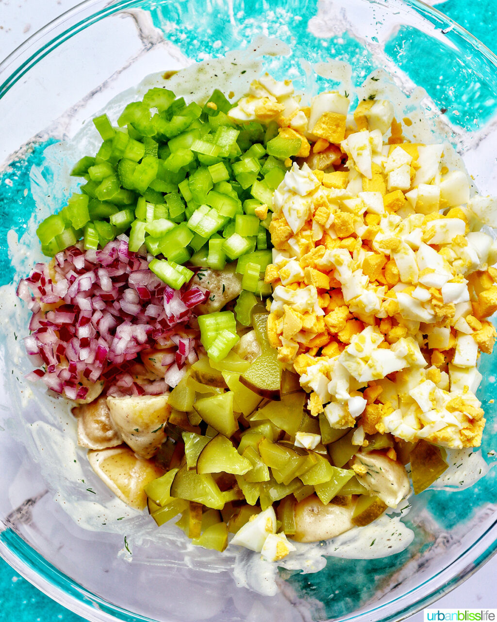 ingredients to make dill pickle potato salad in a bowl.