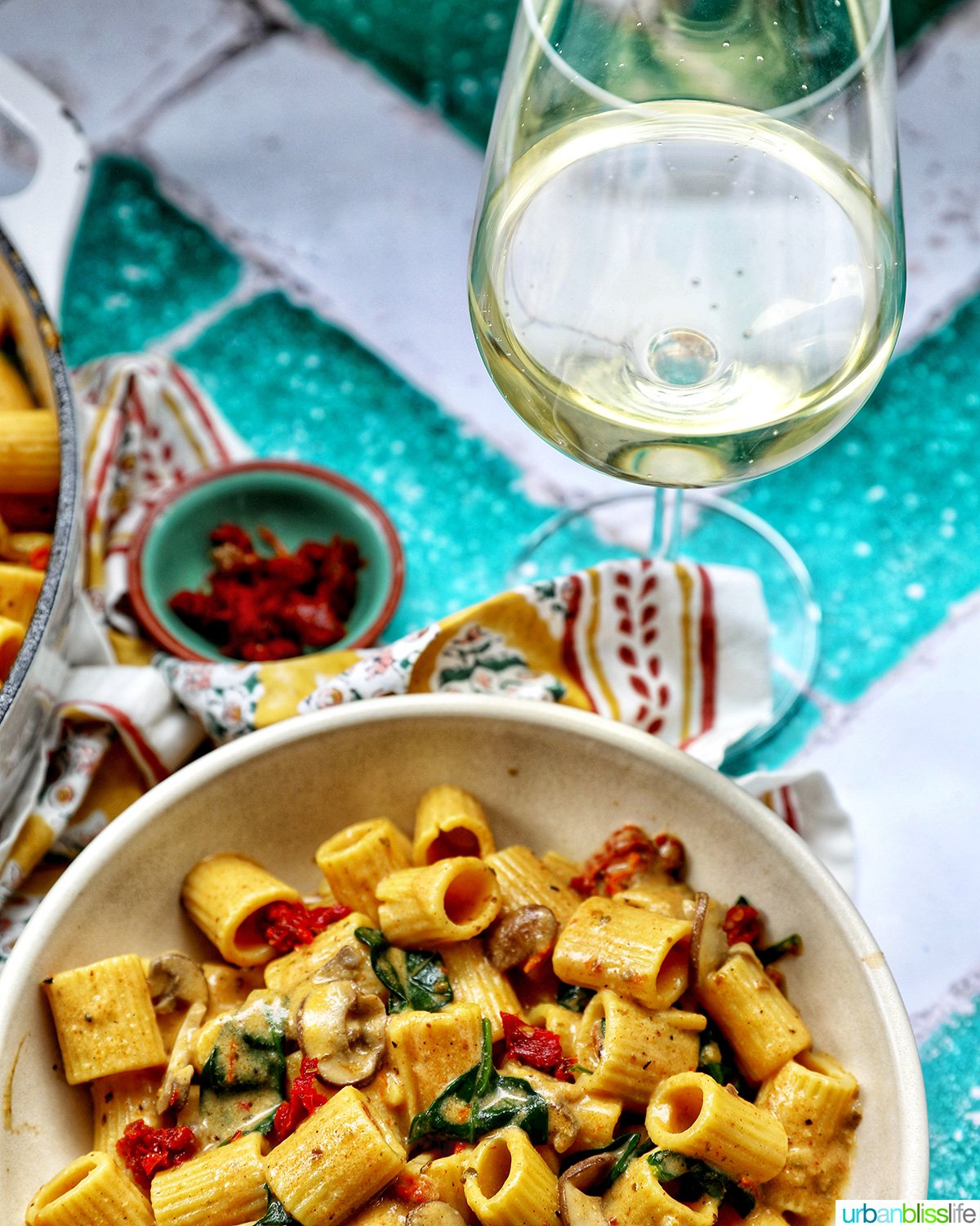 bowl of vegetarian Marry Me Pasta with glass of white wine.
