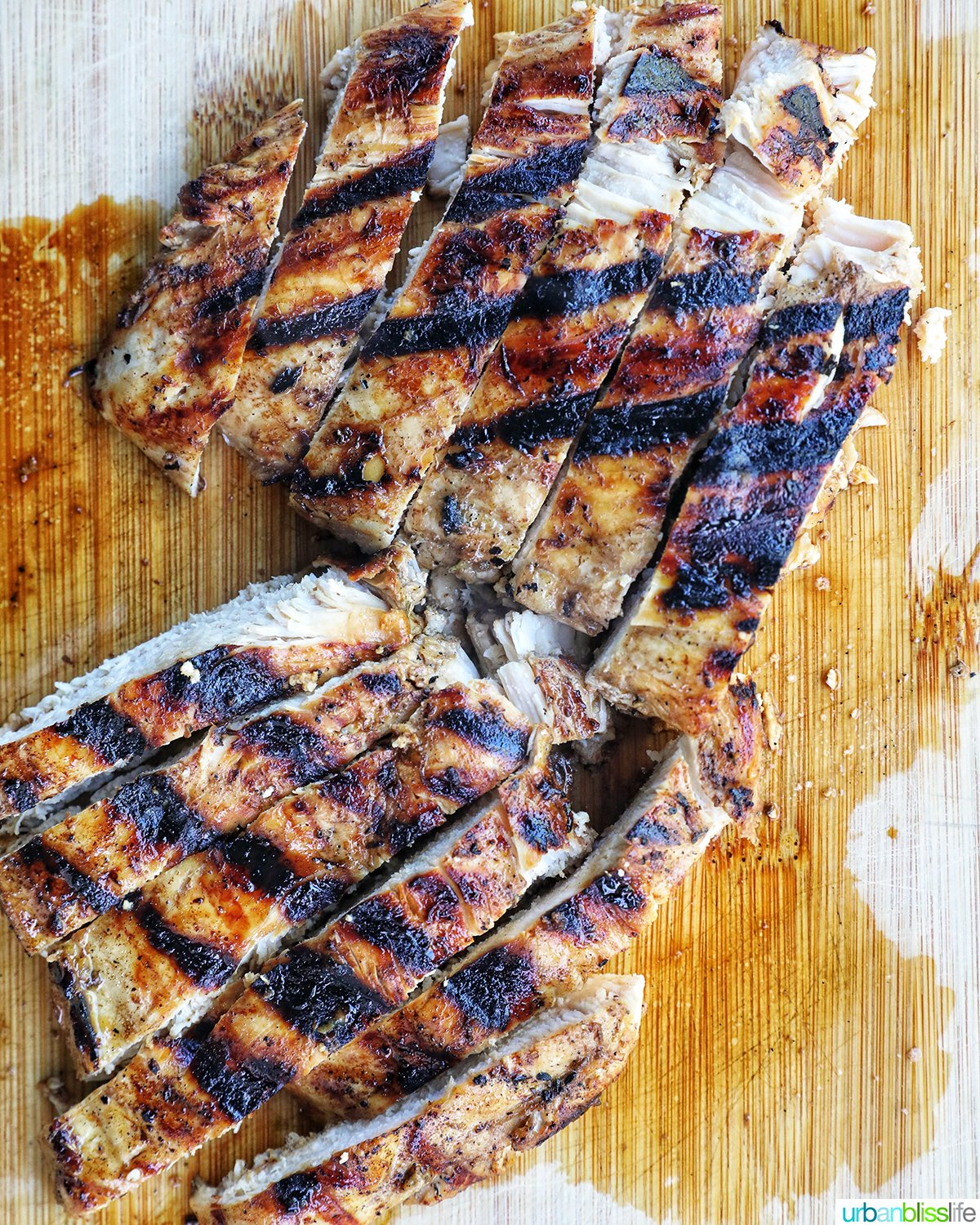 grilled chicken sliced on a cutting board.