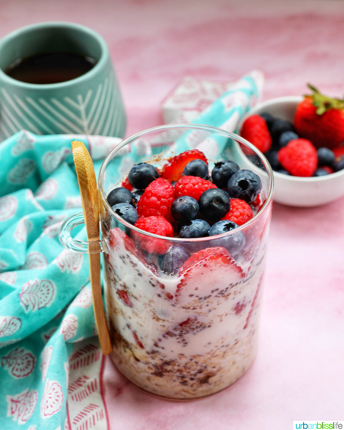 berry overnight oats in a mason jar with cup of coffee.