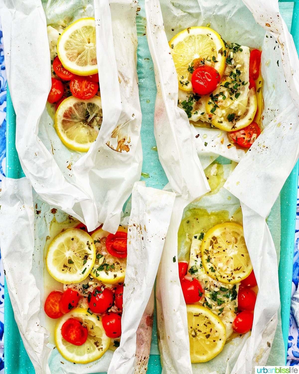 four Cod en Papillote on a baking sheet.