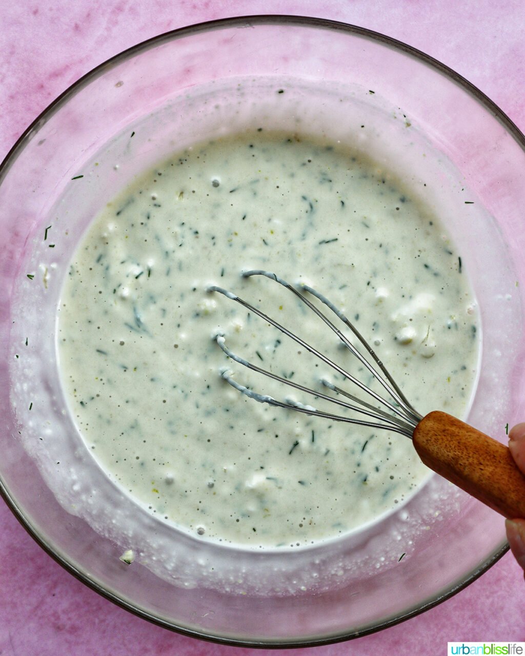 whisk with dressing in a bowl.