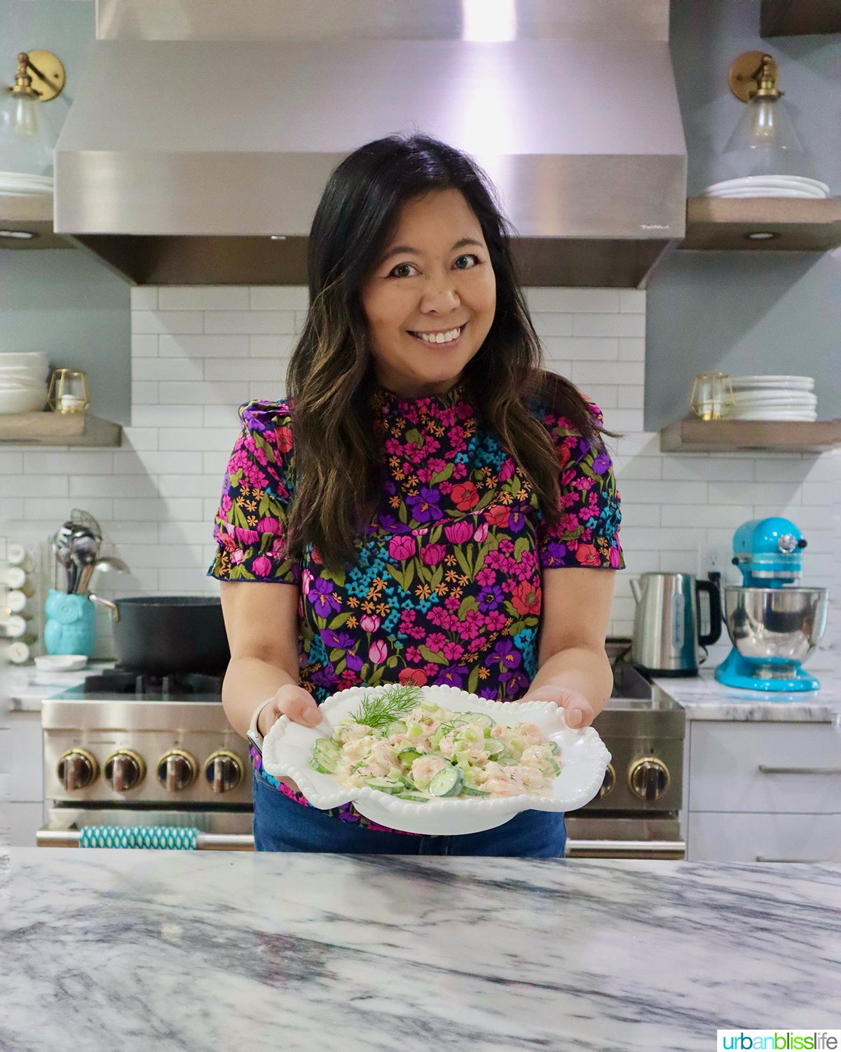 Marlynn holding a bowl of cucumber shrimp salad.