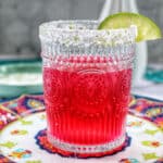 glass of prickly pear margarita with lime slice garnish.