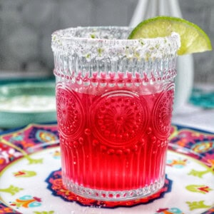 glass of prickly pear margarita with lime slice garnish.