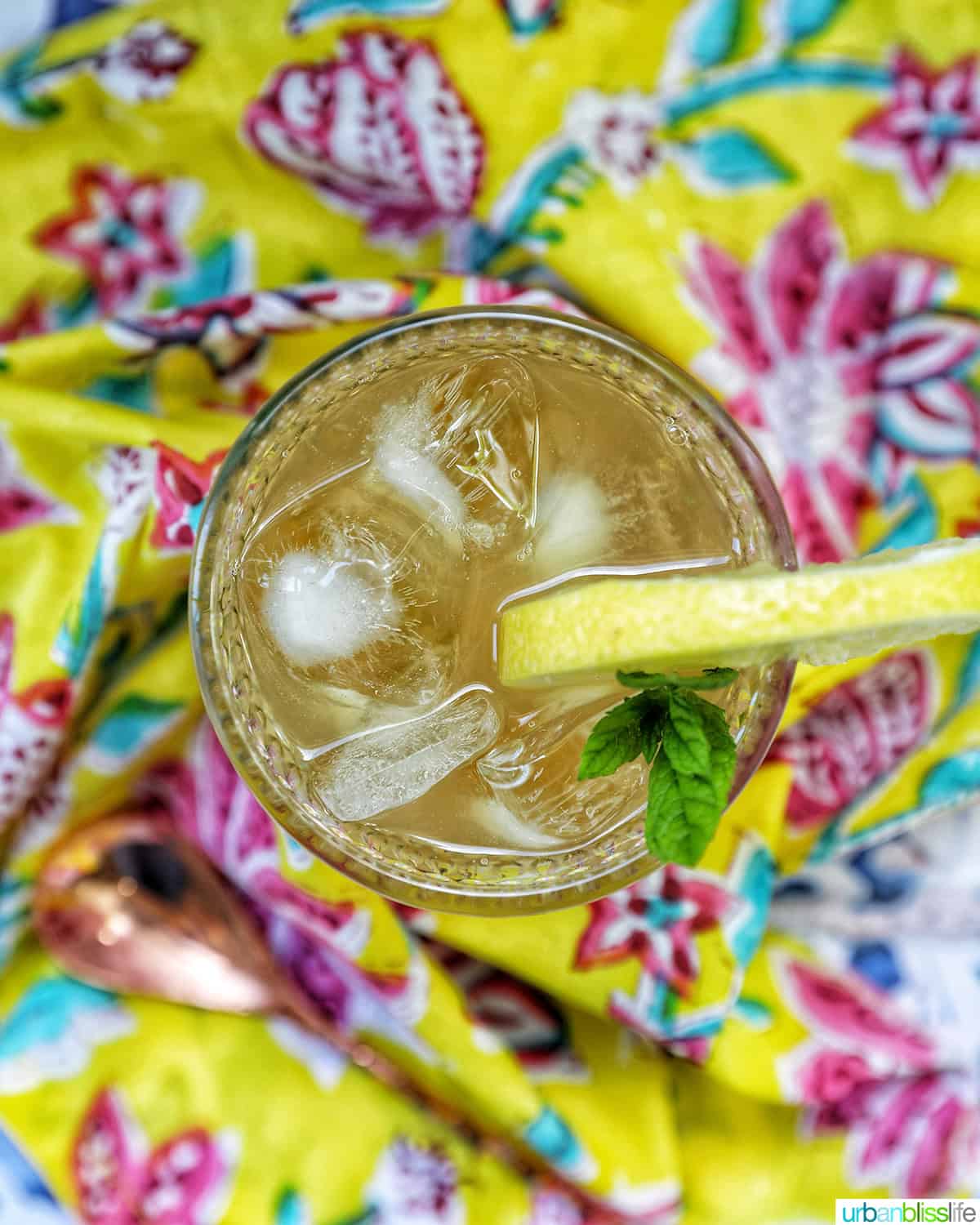 overhead view of glass of bourbon lemonade on a bright colorful napkin.